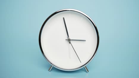 silver alarm clock isolated on black background, showtime 02.57 am or pm.