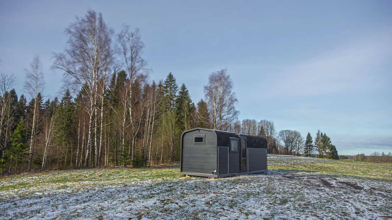 cabaña aislada en un campo con nieve en el suelo