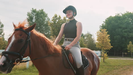 smiling girl in equestrian outfit enjoying riding horseback, handheld shot