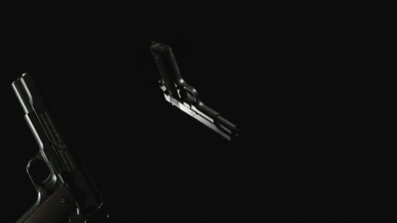 Pistols on the dark background and in blinking lights are falling in slowmotion