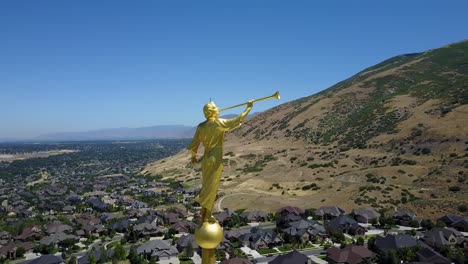 Primer-Plano-Aéreo-Del-ángel-Moroni-Tocando-Su-Trompeta-En-La-Parte-Superior-Del-Templo-Lds-De-Draper,-Utah