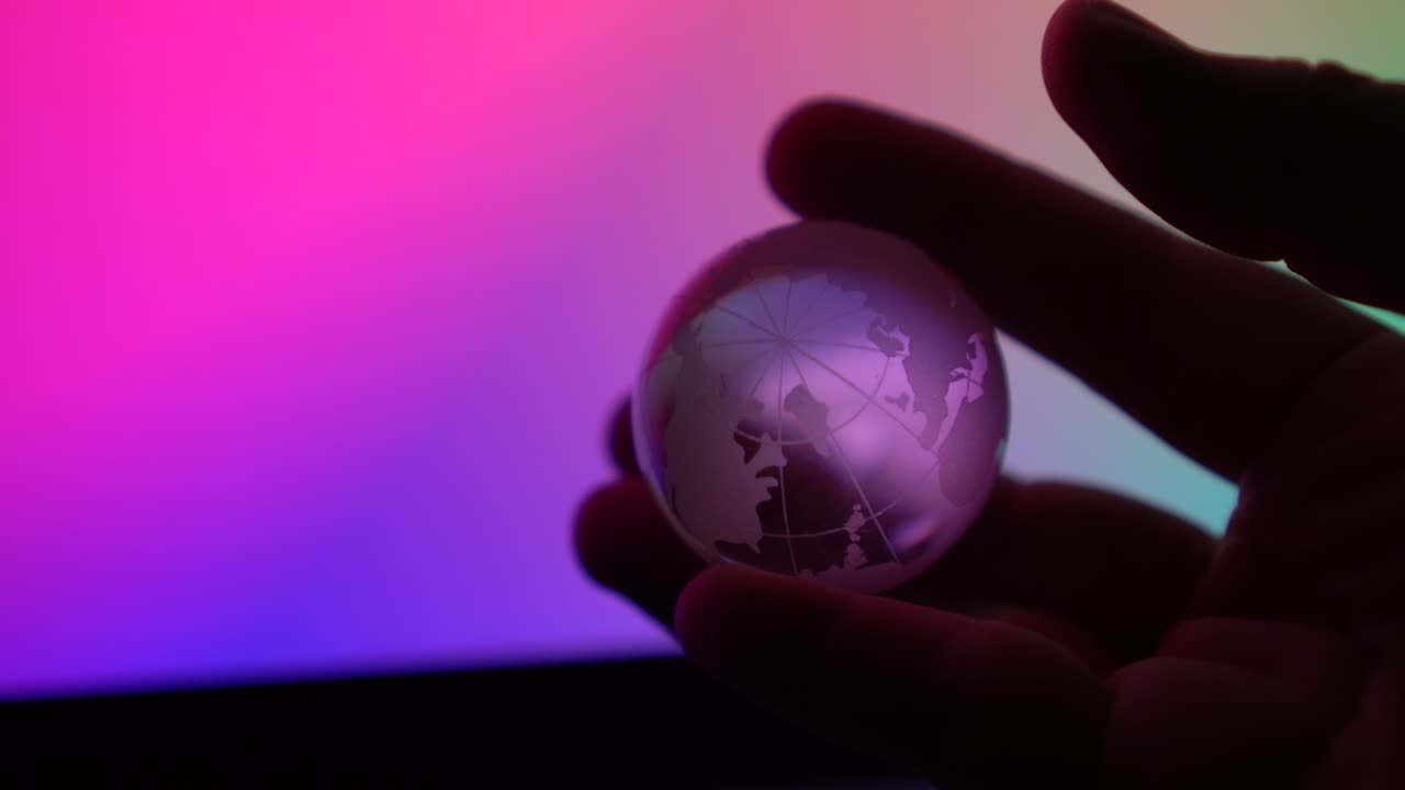 tierra transparente en persona mano girando alrededor en fondo de color neón control abstracto