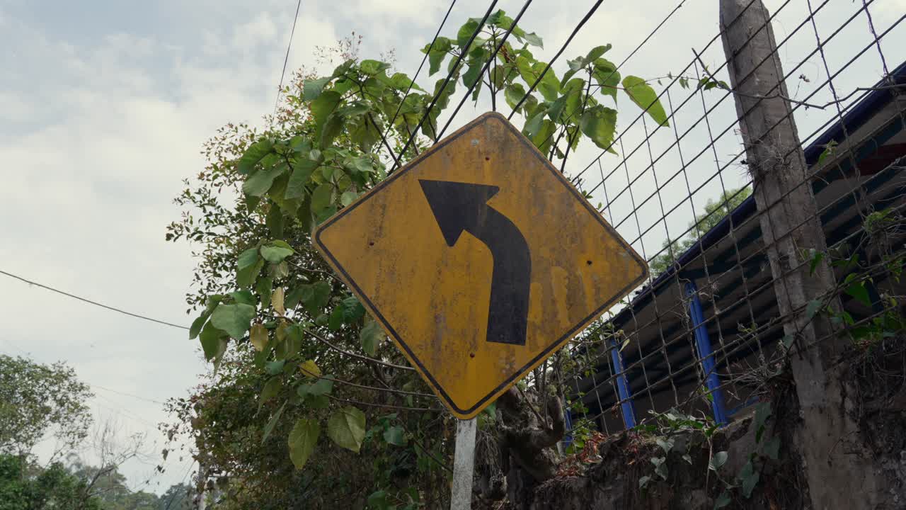 Road sign black arrow indicating a sharp right curve turn yellow diamond-shaped