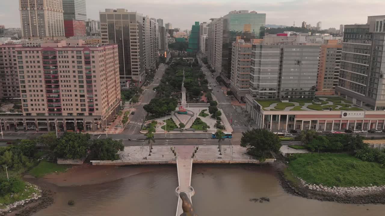 toma aérea que cae detrás de la estatua dorada de kun iam en el área de negocios de nuca en macao