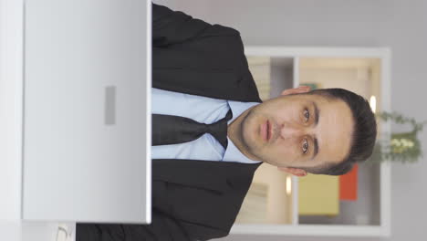 Vertical-video-of-Home-office-worker-man-looking-at-camera-with-fear-and-doubt.