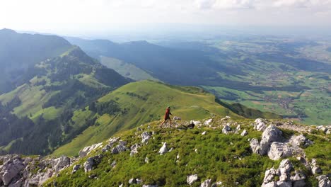 a young man with a hoodie and cap is taking his last steps up to the top after a long and hard hike in the hot sunny weather