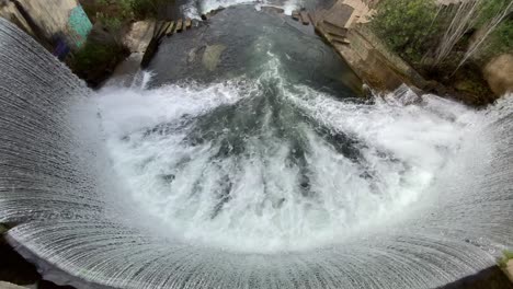 Top-view-of-a-dam-with-a-waterfall-in-proença-a-nova,-Portugal,-surrounded-by-nature