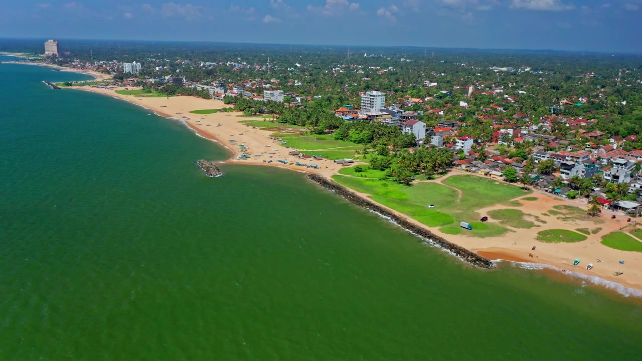 Panoramica aerea cinematografica della spiaggia di Negombo in Sri Lanka, che mostra l'oceano infinito, la costa sabbiosa e un sereno paesaggio marino tropicale.