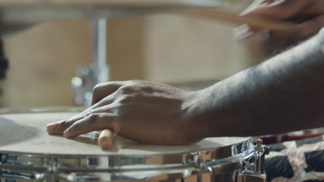 close up of hands of black drummer playing drum set