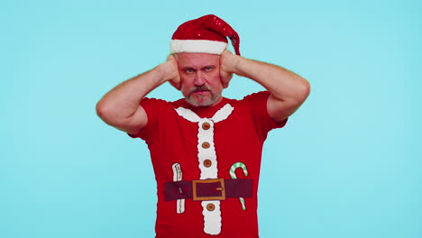 Man-in-Christmas-t-shirt-covering-ears-and-gesturing-no,-avoiding-advice-ignoring-unpleasant-noise