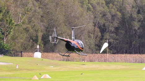 helicopter descends and lands smoothly on grassy area