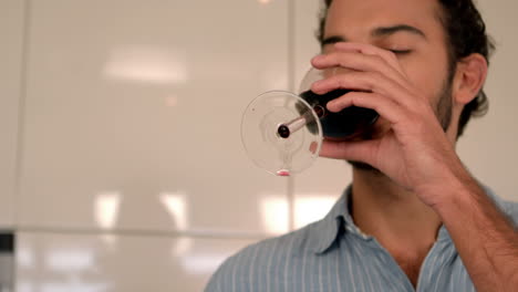 una pareja homosexual feliz bebiendo vino rojo.