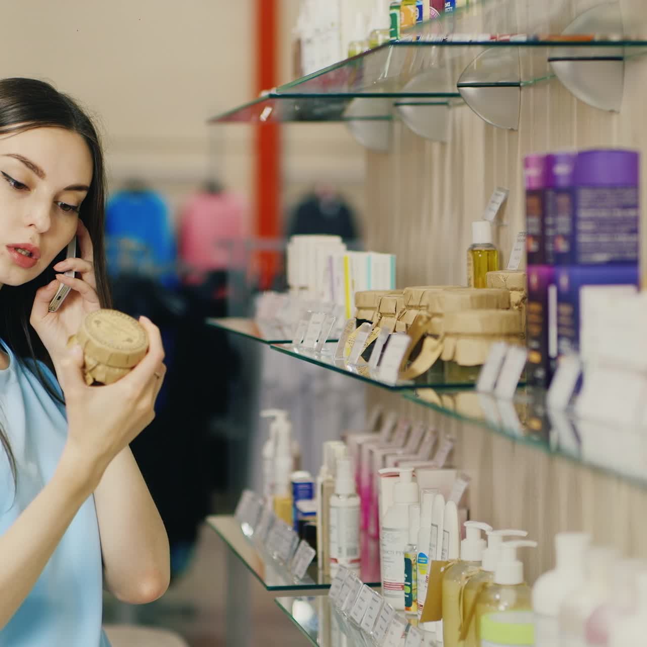 쇼핑하는 동안 핸드폰에 얘기하는 여자