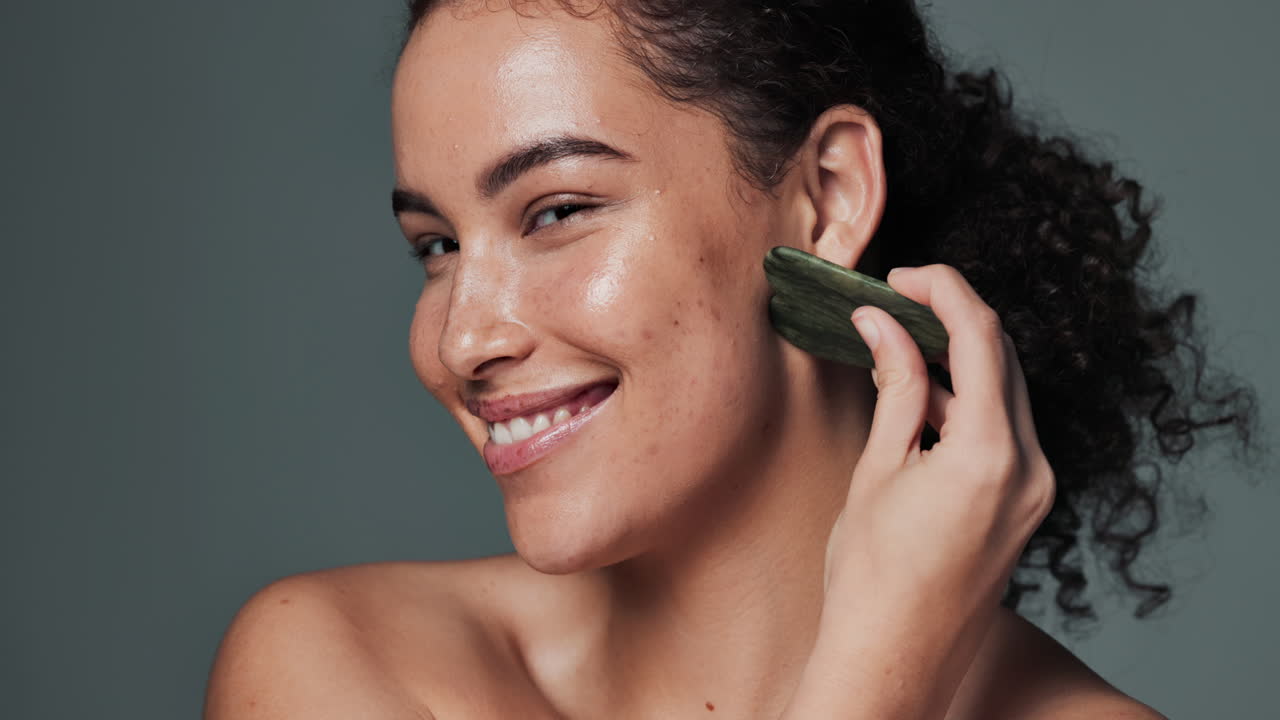 Woman using gua sha for facial massage