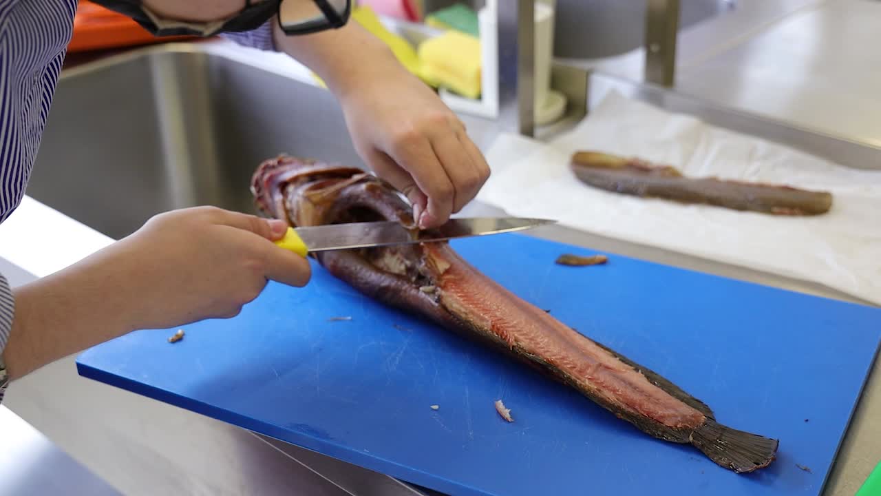 셰프의 손이  ⁇ 질을 벗기고 물고기를 잘라