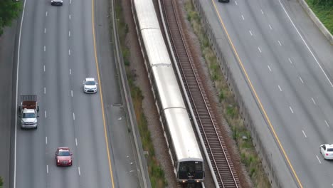 drone shot of metropolitan atlanta trains and cars passing through georgia state route 400, buckhead subway station