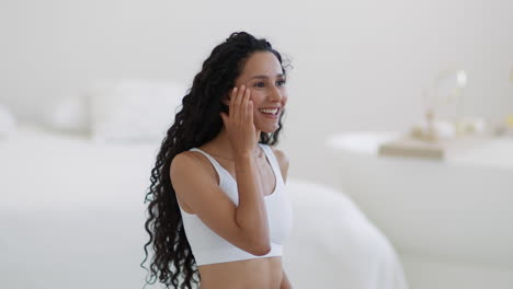 woman smiling and touching her face