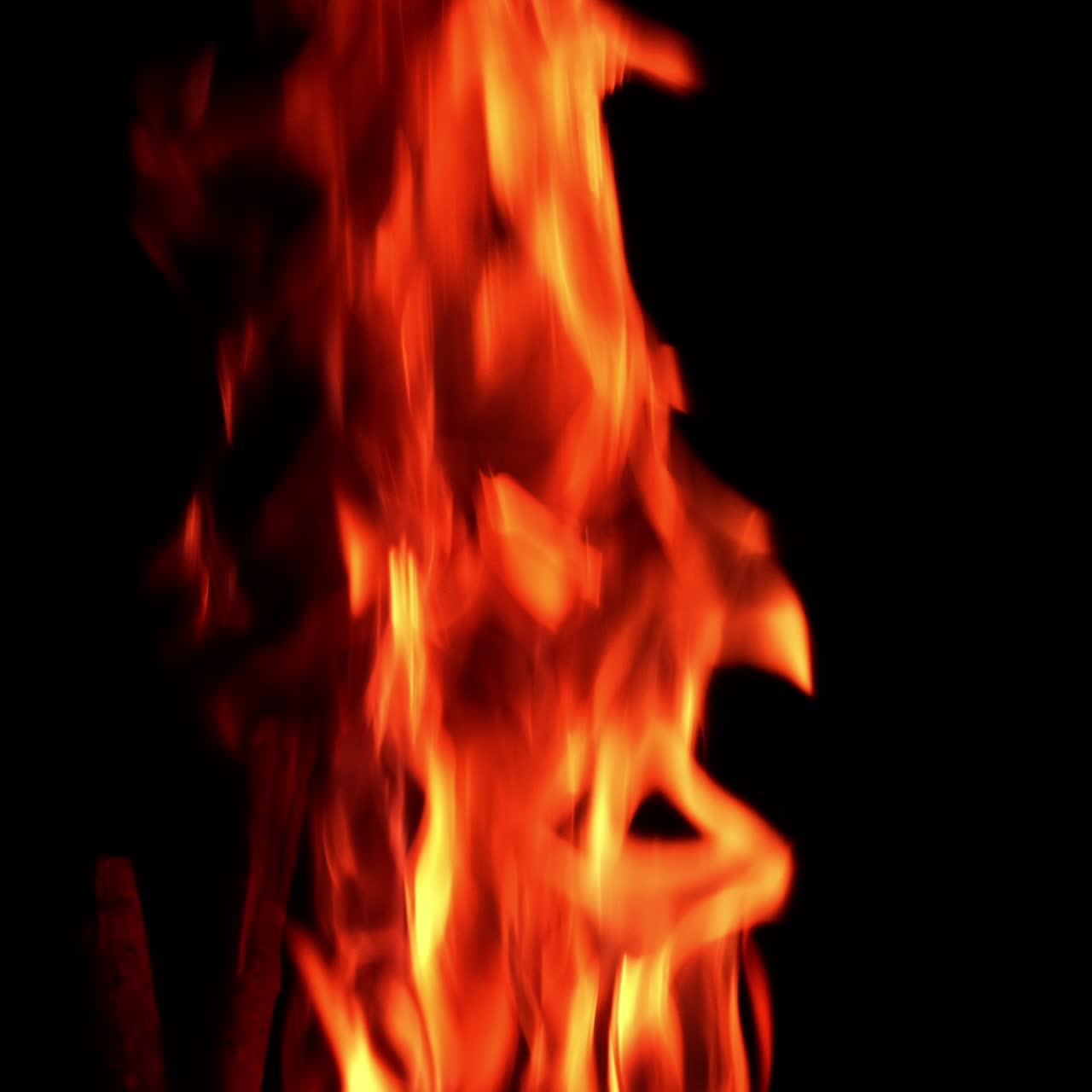 Beautiful red fire burning at night. Little sparkles fly up from the flame. Close up