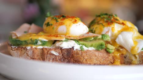 close-up of a delicious eggs benedict with avocado toast