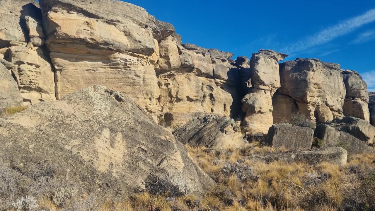 Varmt kvällsljus belyser de gamla klippformationerna vid Punta Walichu nära El Calafate, Argentina, och avslöjar en förhistorisk grottbosättning uthuggen i karga patagoniska klippor