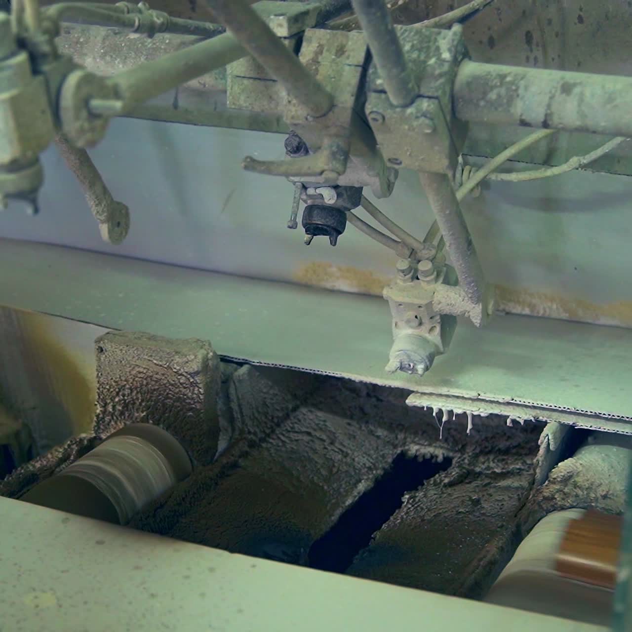 Varnishing machine at door production factory. Wooden plank is moved along the conveyor over the rollers