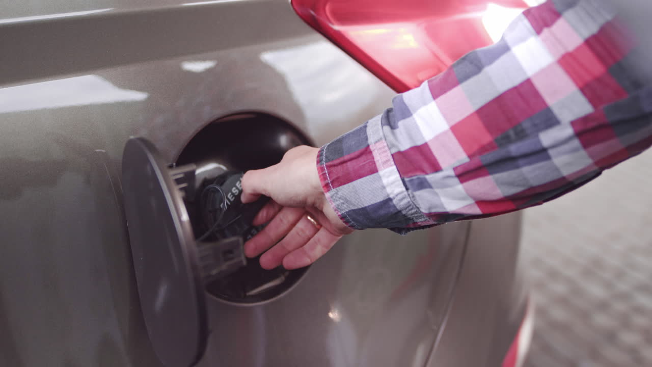 Person filling a diesel car's fuel tank