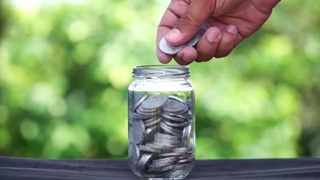 saving money: putting coins in a jar