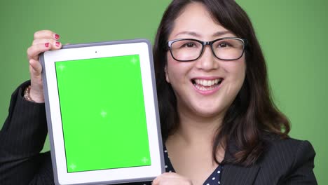 una hermosa mujer de negocios asiática madura mostrando una tableta digital