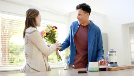 Feliz-Pareja-Diversa-Regalando-Flores-Y-Abrazándose-En-Casa,-En-Cámara-Lenta