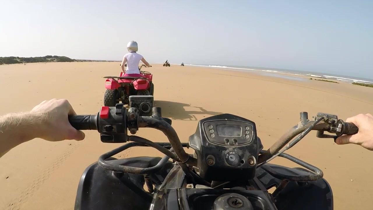 POV di quad che sfrecciano e gareggiano sulla spiaggia di Sidi Kaouki, Marocco.