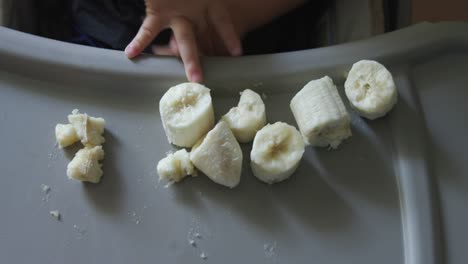 baby playing with banana pieces