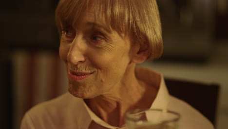 Smiling-senior-woman-making-toast-during-dinner.-Mature-lady-talking-with-family