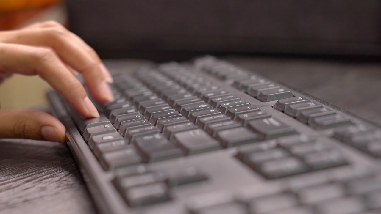 Close Up Hands Shot Of A Office Worker Typing On A Black Computer Keyboard On A Desk.