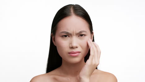 Close-up of a woman experiencing pain or discomfort, holding her temple