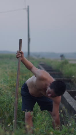 Shirtless man working in a rural field
