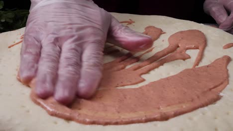 preparando una pizza con salsa