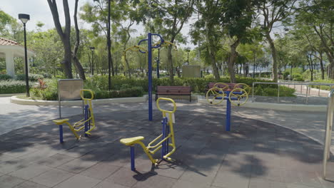 A-gimbal-smoothly-tracks-around-an-empty-park,-featuring-specialized-fitness-equipment-designed-for-elderly-individuals