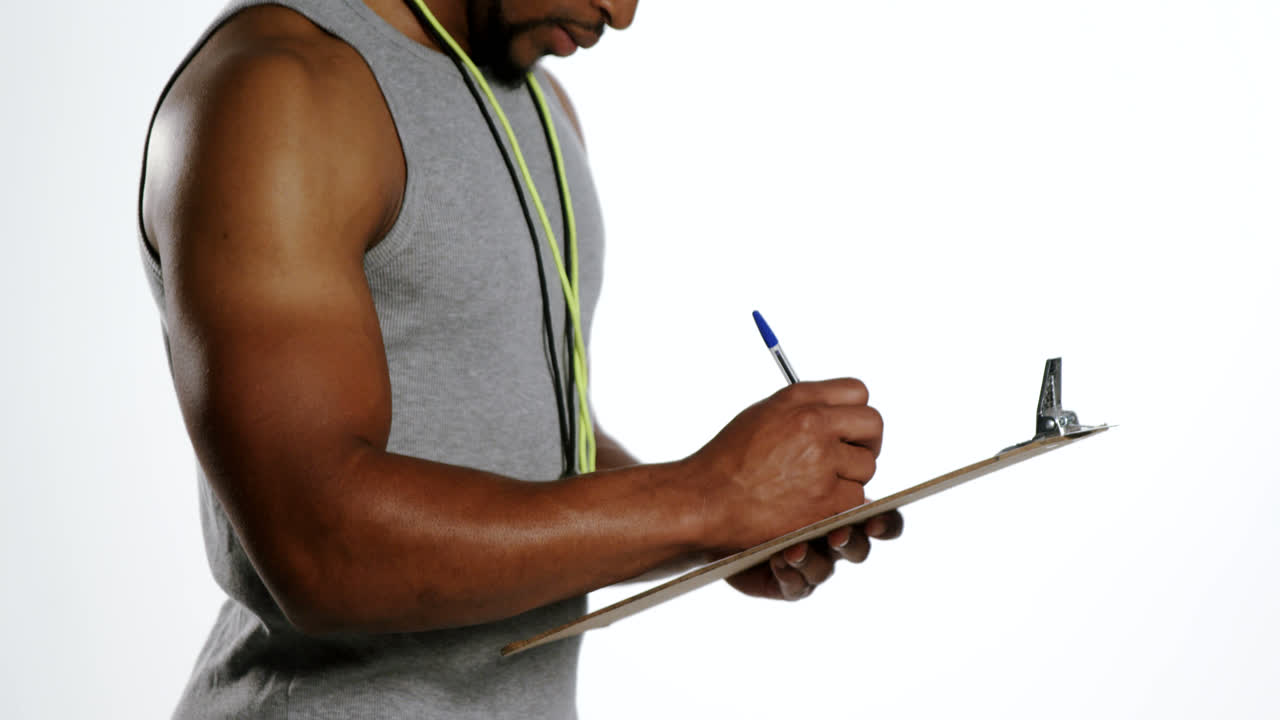entrenador atento escribiendo en el clipboard