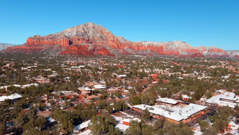 Ciudad-De-Sedona-Durante-El-Invierno-Con-Rocas-Rojas-Cubiertas-De-Nieve,-Antena