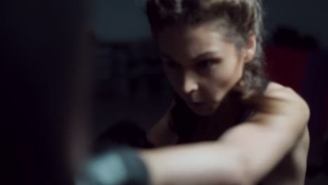 Beautiful-young-woman-punching-bag-in-fitness-studio.-Boxing-in-Slow-Motion