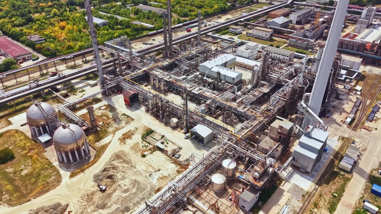 Complesso industriale in un'area remota con varie strutture e macchinari visibili dall'alto durante il bel tempo