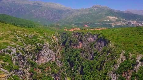 Flying-above-the-stunning-Canyon-of-Gjipe-with-large-mountains-in-the-background-in-the-Albanian-Riviera,-Eastern-Europe