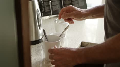 Senior-man-preparing-coffee-in-kitchen-at-home-4k