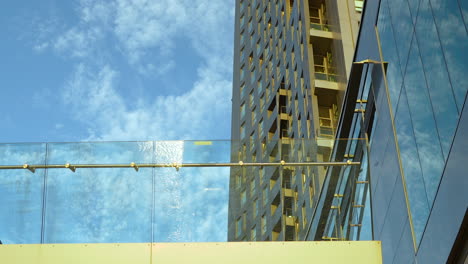 Modern-high-rise-architecture-with-glas-and-steel-against-a-blue-sky-with-clouds