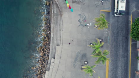 Video-Aéreo-Que-Muestra-Una-Vista-De-Pájaro-Del-Malecón-De-Puerto-Vallarta,-Capturando-La-Impresionante-Costa-Con-Olas-Rompiendo-En-La-Orilla