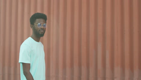 cheerful african american  man walking outdoors and smiling at camera