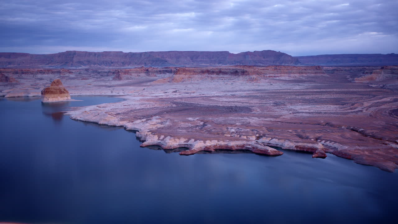 Drone shot panning across dramatic landscape with Lake Powell and glen canyon in distance
