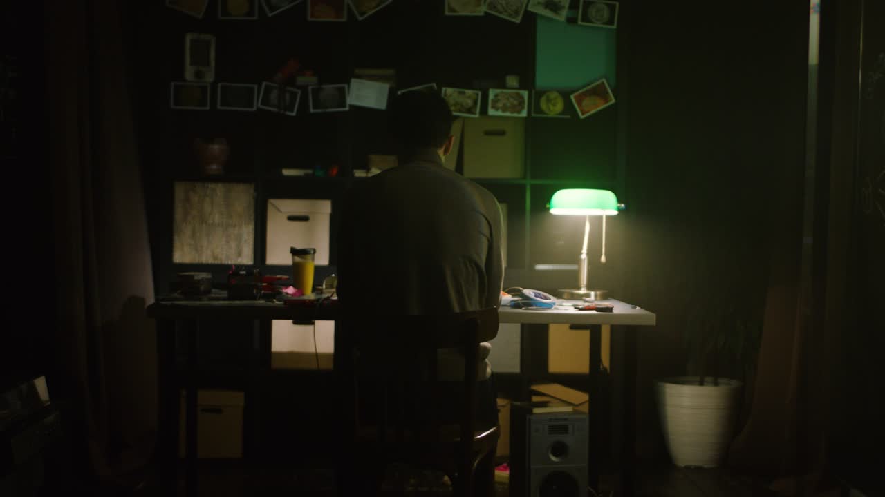 persona que trabaja en una sala de estudio oscura