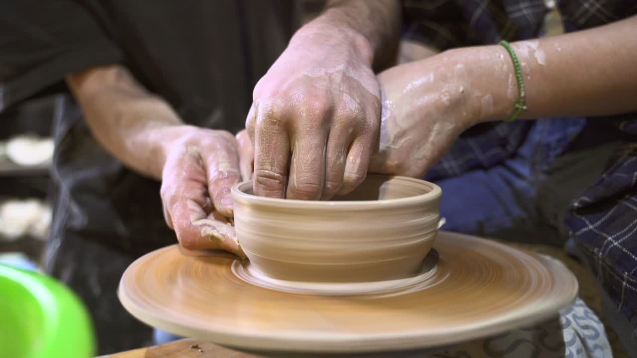 도자기 수업: 두 명의 학생이 그을 만들고 있습니다.