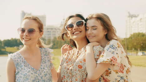 three happy women friends in a park